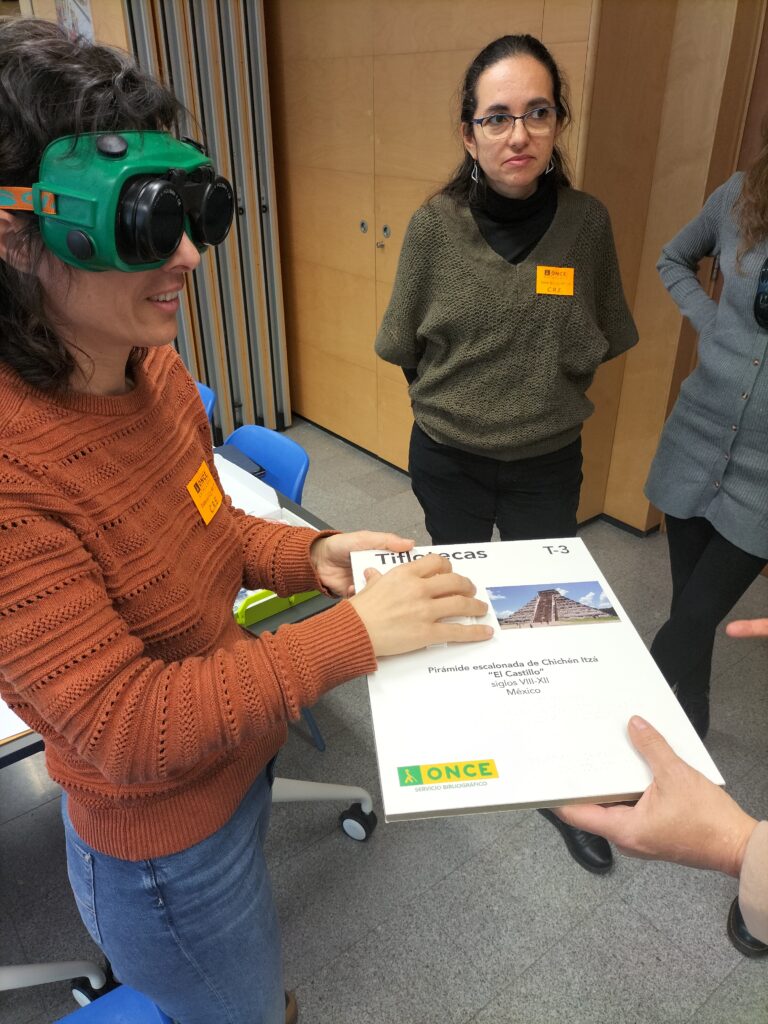 Inclusive Science Course organized by IBEC and ONCE. A person tests educational materials adapted for low vision and blindness using special glasses.